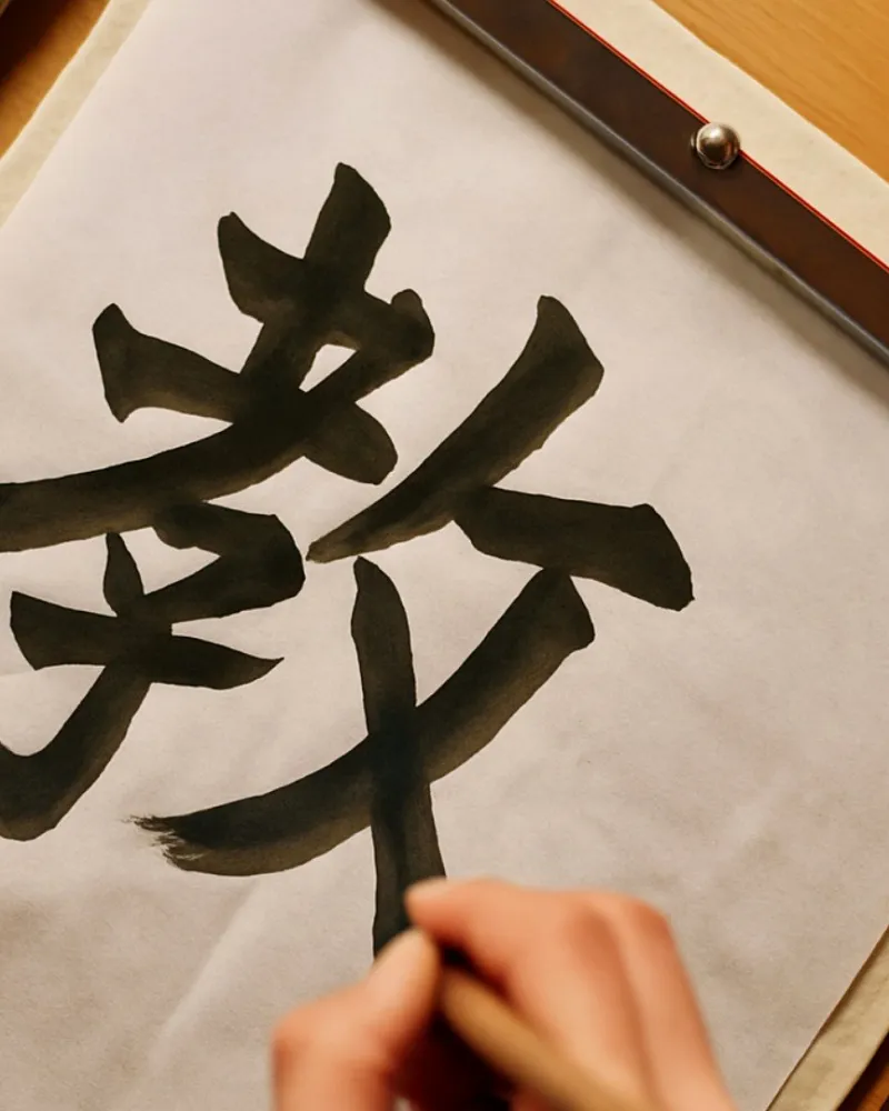 手执毛笔书写“教”字