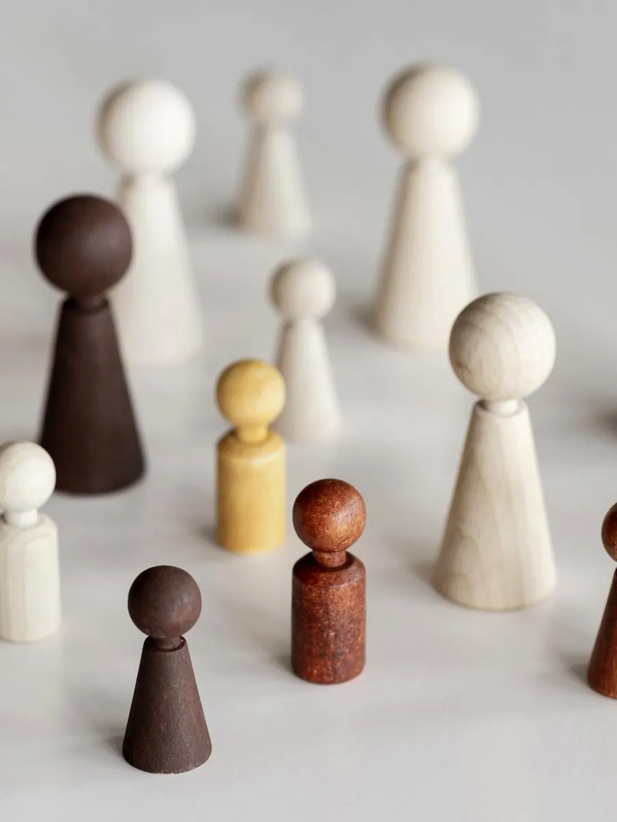 Wooden peg figures of different colours arranged in a group