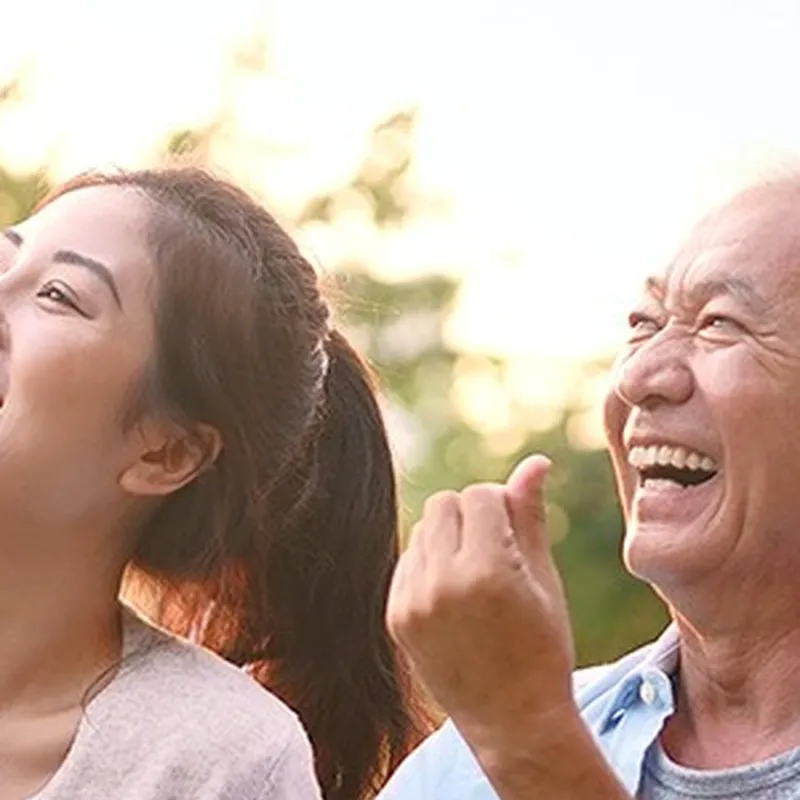 一位年轻女士与长者在户外欢笑
